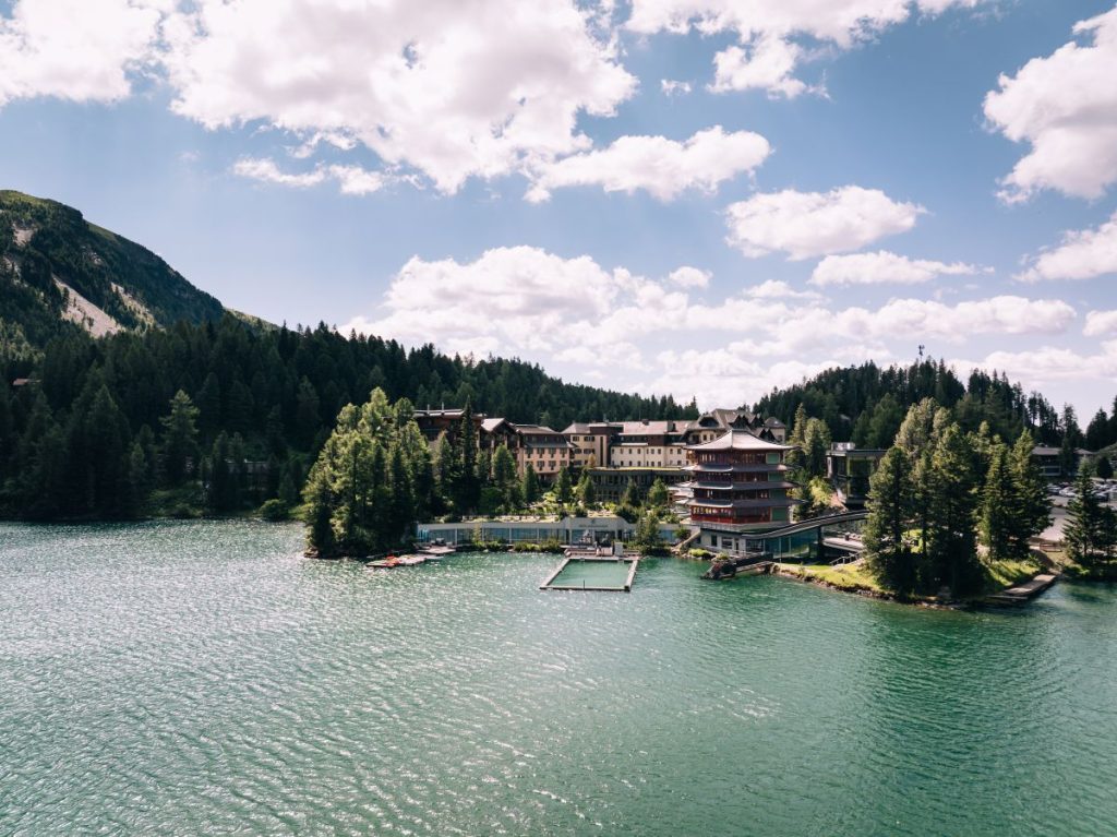 Hotel Hochschober am Turracher See vor Bergpanorama.