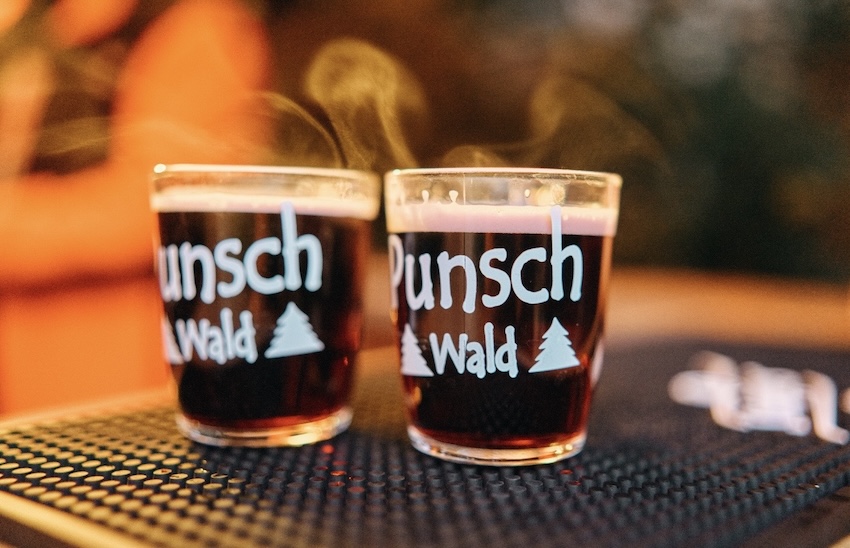 Zwei dampfende Gläser des Punschwald Stuttgart stehen auf einer Bar-Matte.